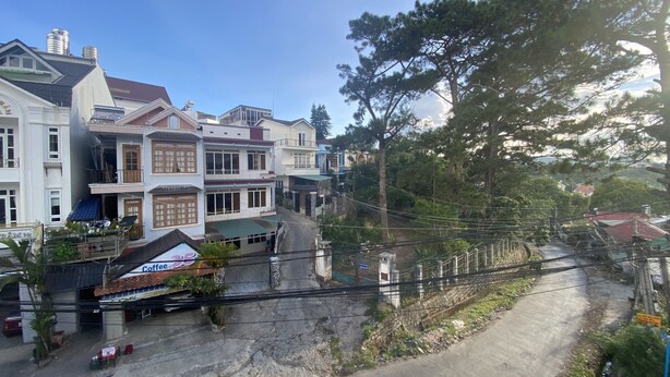 A multi-story building with a mix of residential and commercial spaces, including a visible storefront. - Thu Tam Hotel (Cam Ly - Da Lat)