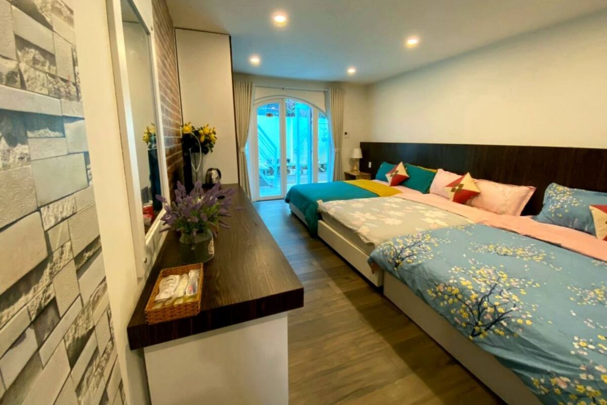 A modern hotel room with a large bed, a small desk, and a view of the outside.