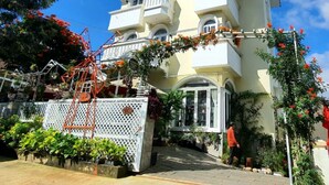 A multi-story building with balconies, a white picket fence, and potted plants. - Pho Hoa Boutique Villa (Cam Ly - Da Lat)