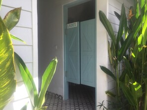 Una puerta con un letrero que dice "LADIES" que da a un cuarto con piso de baldosas.