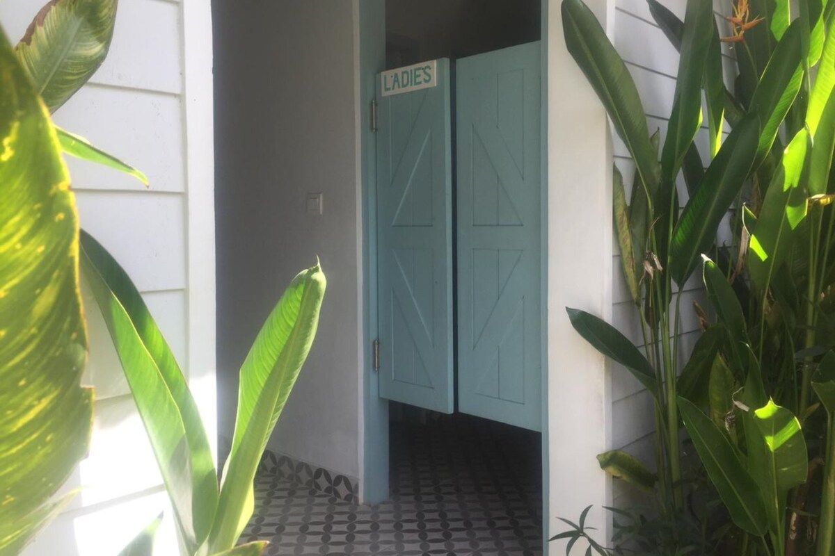 Una puerta con un cartel que dice "LADIES" y un piso de baldosas.