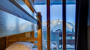 A wooden bunk bed room with a view of snow-capped mountains through a glass door. - Appartement Bellevue 207 - La Tzoumaz, 4 Vallees (La Tzoumaz)