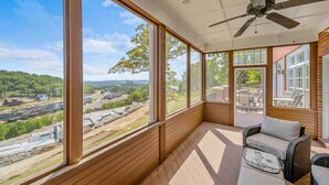 A sunlit room with large windows, a ceiling fan, and wicker furniture. - LakeViews, Indoor/Outdoor Pools, HotTub & Fire Pit (Branson)