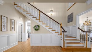 A staircase with white railings and wooden steps, leading to a landing with a wreath. - LakeViews, Indoor/Outdoor Pools, HotTub & Fire Pit (Branson)