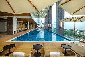 Relax by the large pool surrounded by lounge chairs and small tables.