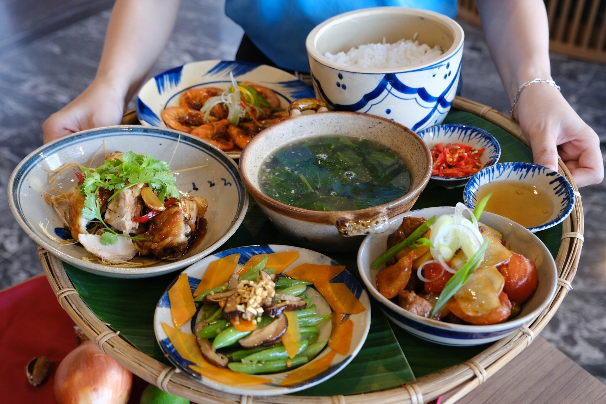 A tray with various dishes including rice, soup, and stir-fried vegetables.
