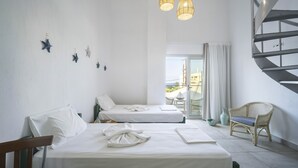 A hotel room with two beds, a wicker chair, a spiral staircase, and a view of the outside. - Anemi Hotel (Hersonissos)