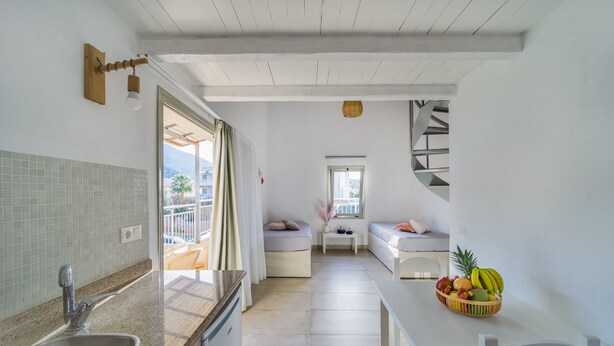 A modern kitchen with a sink, countertop, and a fruit bowl on the table. - Anemi Hotel (Hersonissos)