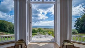 Una stanza con vista su un giardino e un tavolo con sedie.