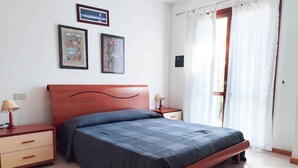 Una camera da letto con un letto di legno, due comodini con lampade e una finestra con tende.