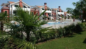 Una fila di edifici moderni a più piani con una piscina in primo piano.