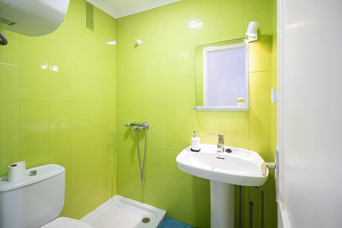 Een badkamer met een toilet, douche en wastafel.