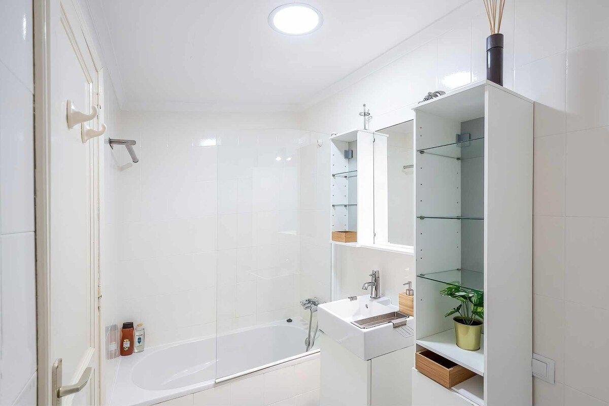 Une salle de bain moderne avec une douche à parois de verre, un lavabo blanc et un meuble à miroir.