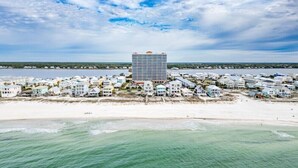 A coastal hotel with a central building surrounded by beach houses, overlooking a beach and the ocean. - Corner Condo w/ Panoramic Views of the Gulf & Lagoon | Pool & Sauna | Sleeps 10 (Gulf Shores)