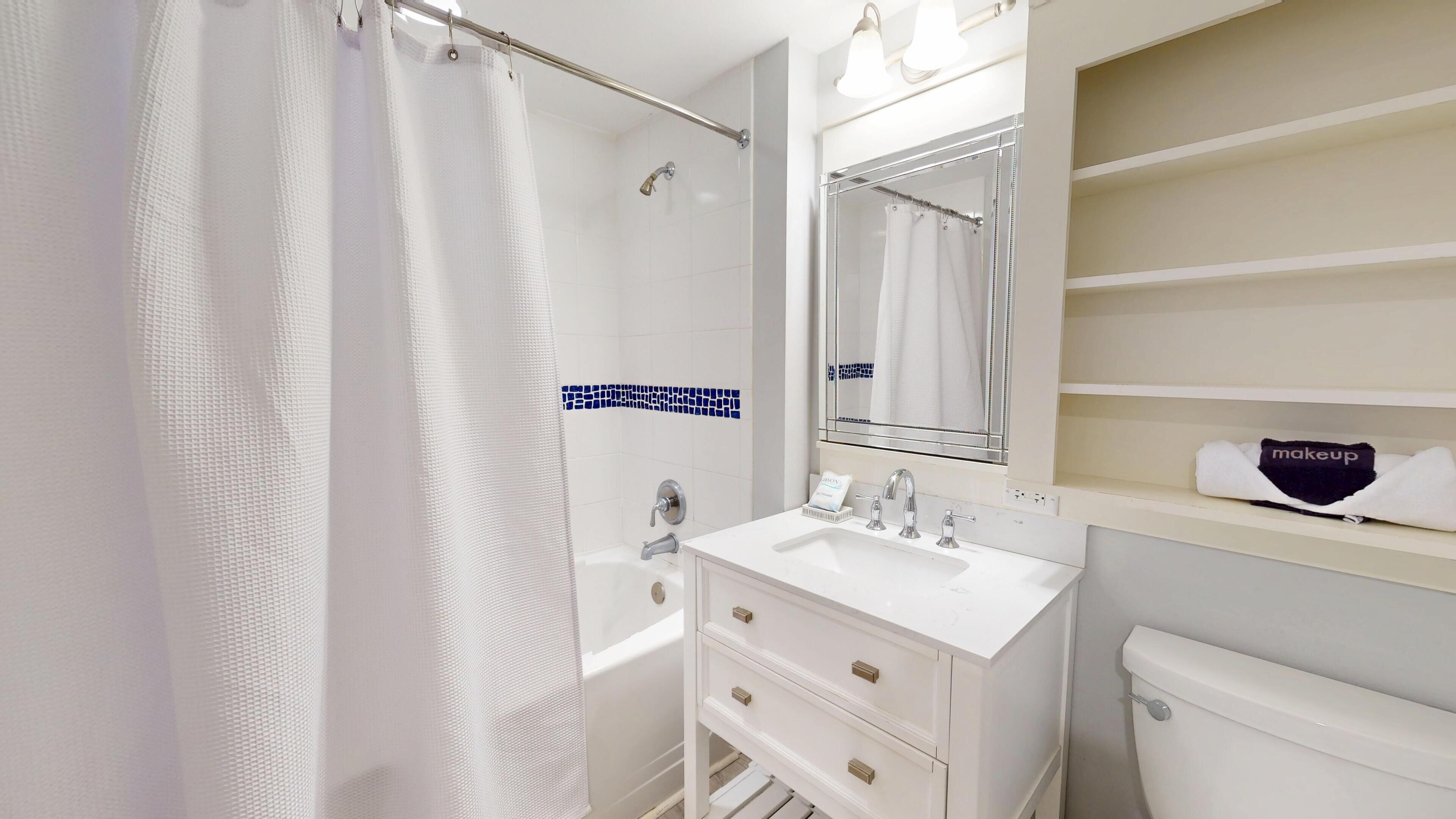 A modern bathroom with a shower, a sink, and a toilet.