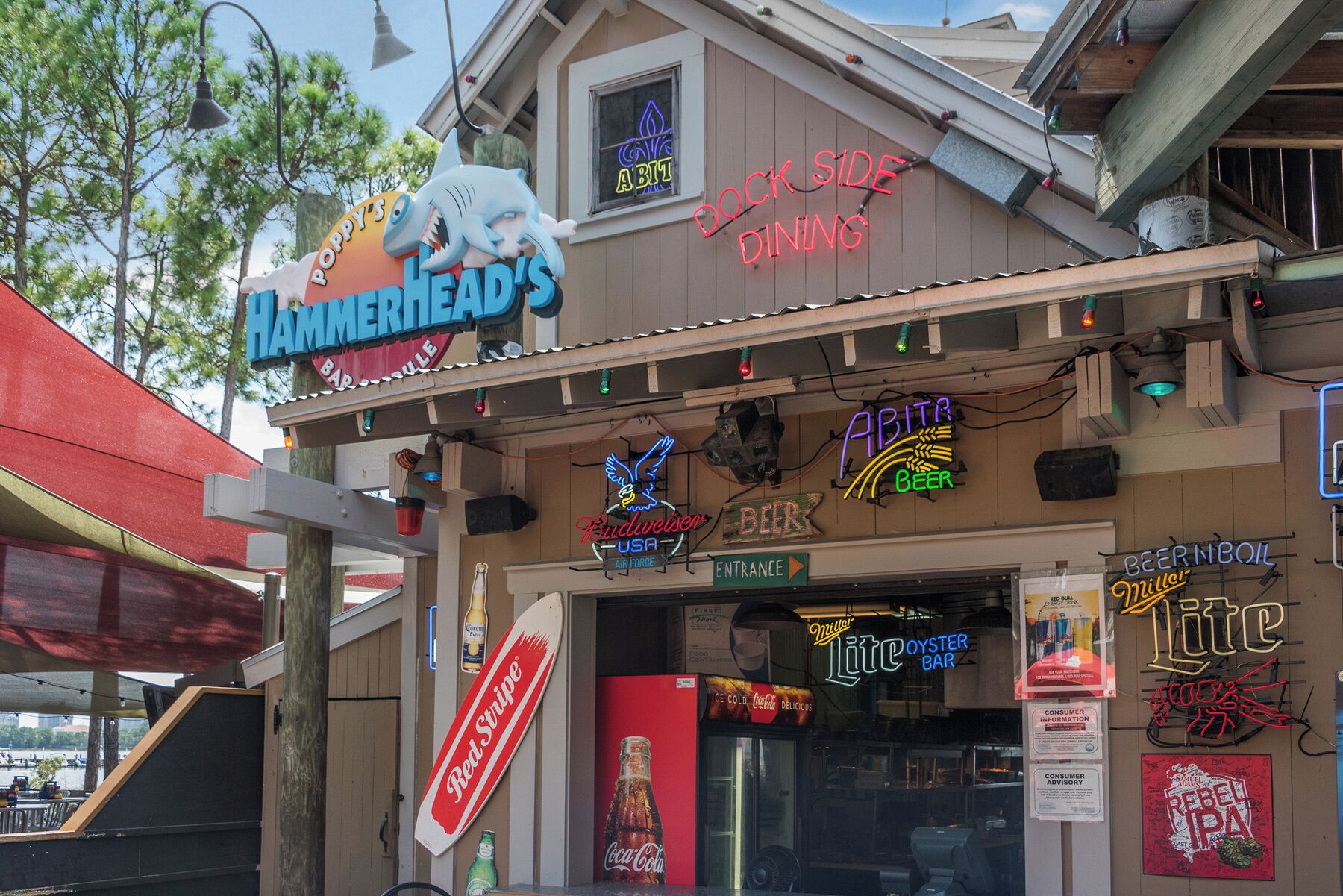 Eine Bar namens 'Hammerhead's Bar & Grill' mit Neonreklame für 'Beer', 'Bier vom Fass' und 'Beer on the Rocks'.