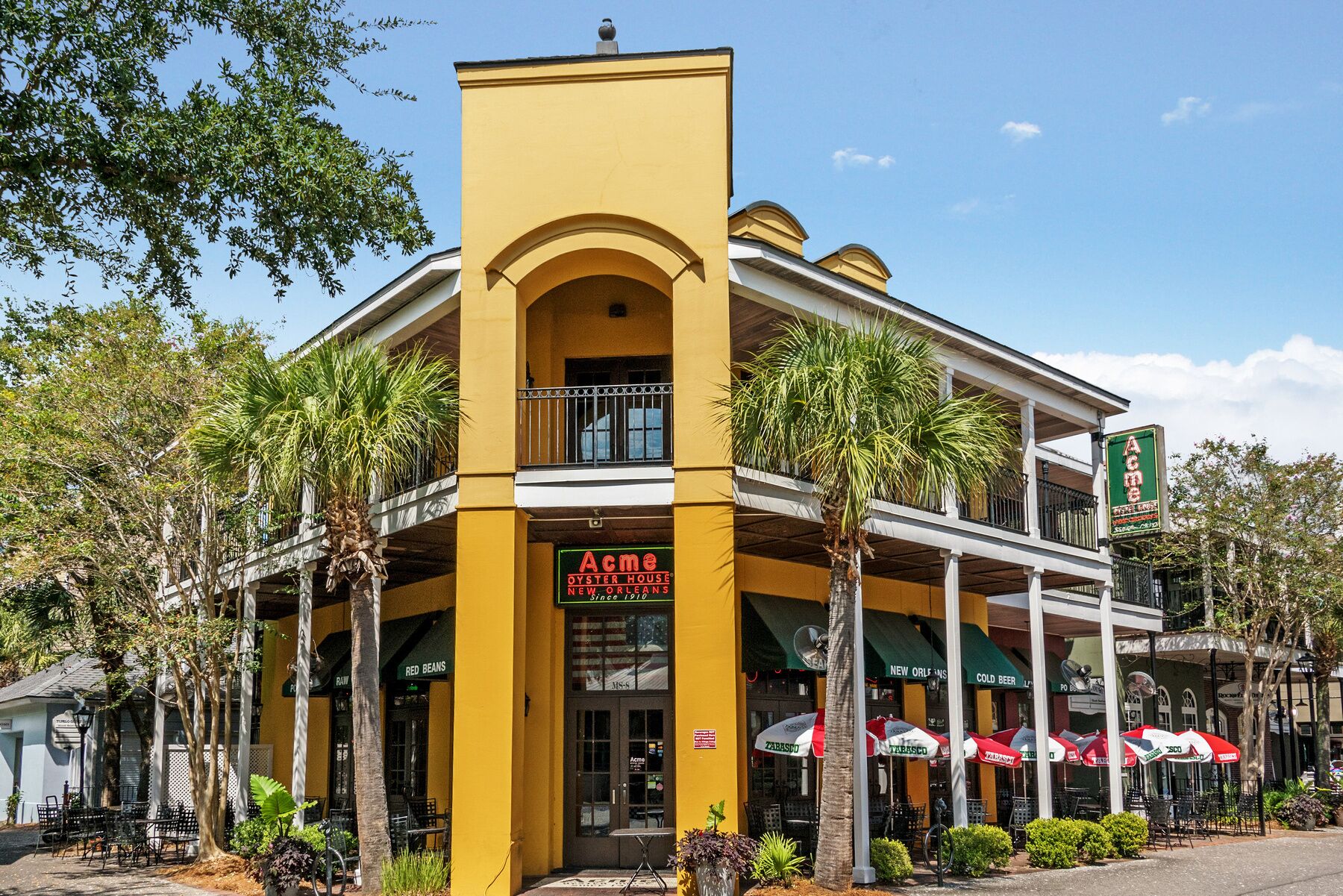 Un edificio amarillo con un letrero que dice 'Acme Oyster House New Orleans'.