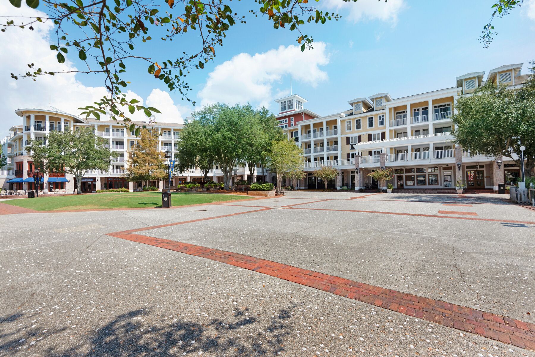 A hotel courtyard with a central open space, surrounded by multi-story buildings with balconies and storefronts.