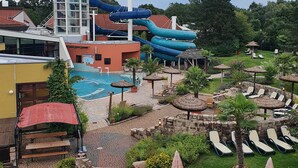 Parque acuático con una piscina grande, toboganes y zonas de descanso.