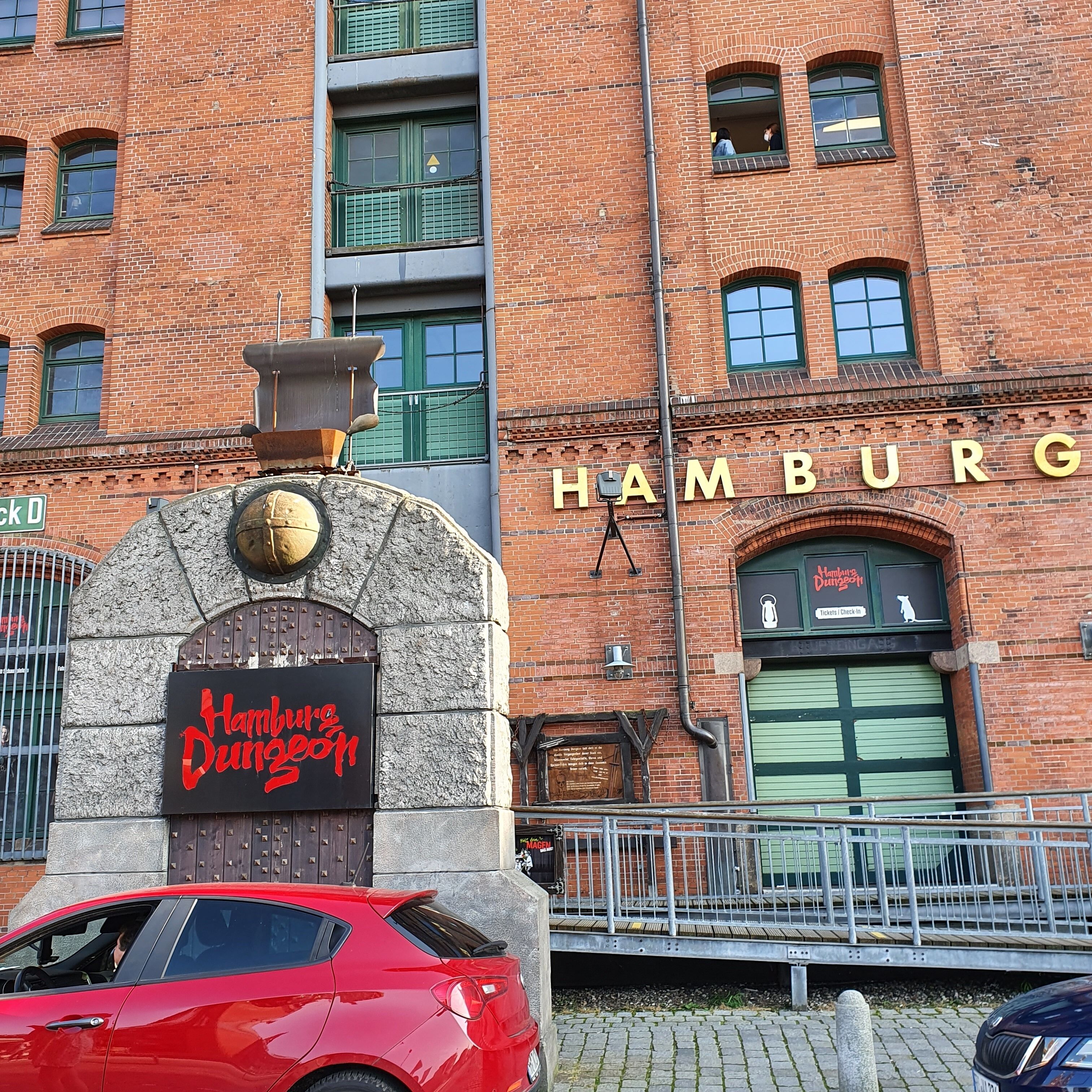 Ein Backsteinhaus mit einem Schild, auf dem "Hamburg" steht, und einem weiteren Schild für "Hamburg Dungeon".