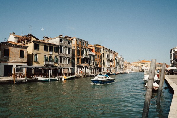 A canal with buildings on one side and a wooden pier on the other. - Palazzo Veneziano, located right on Venice's main canal, with a rooftop terrace (Venezia)