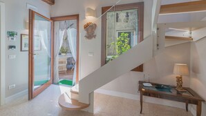 Ein modernes Interieur mit einer Treppe, einem Essbereich und Blick ins Freie.