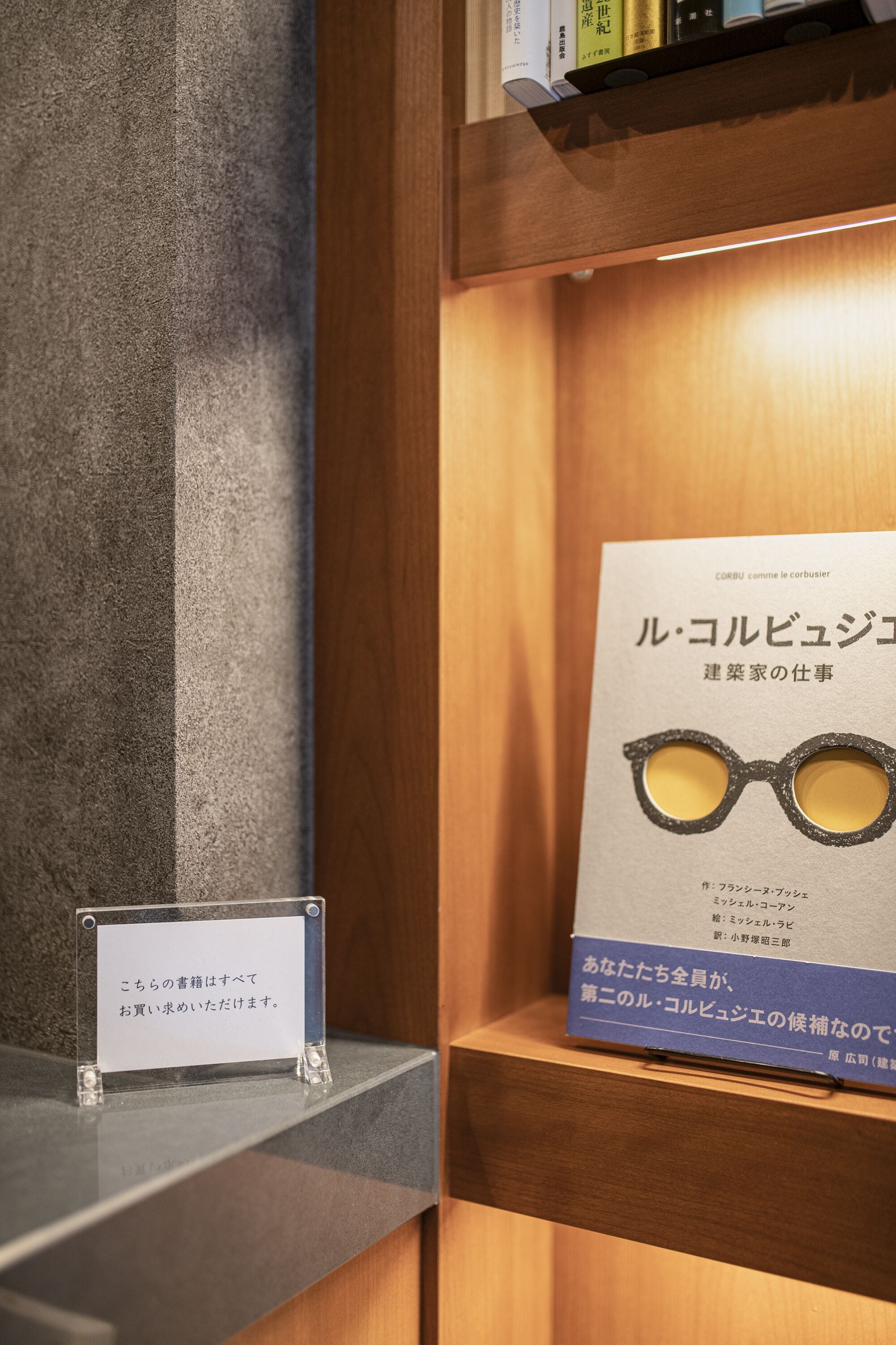 A display with a book and a pair of glasses, a sign, and a shelf.