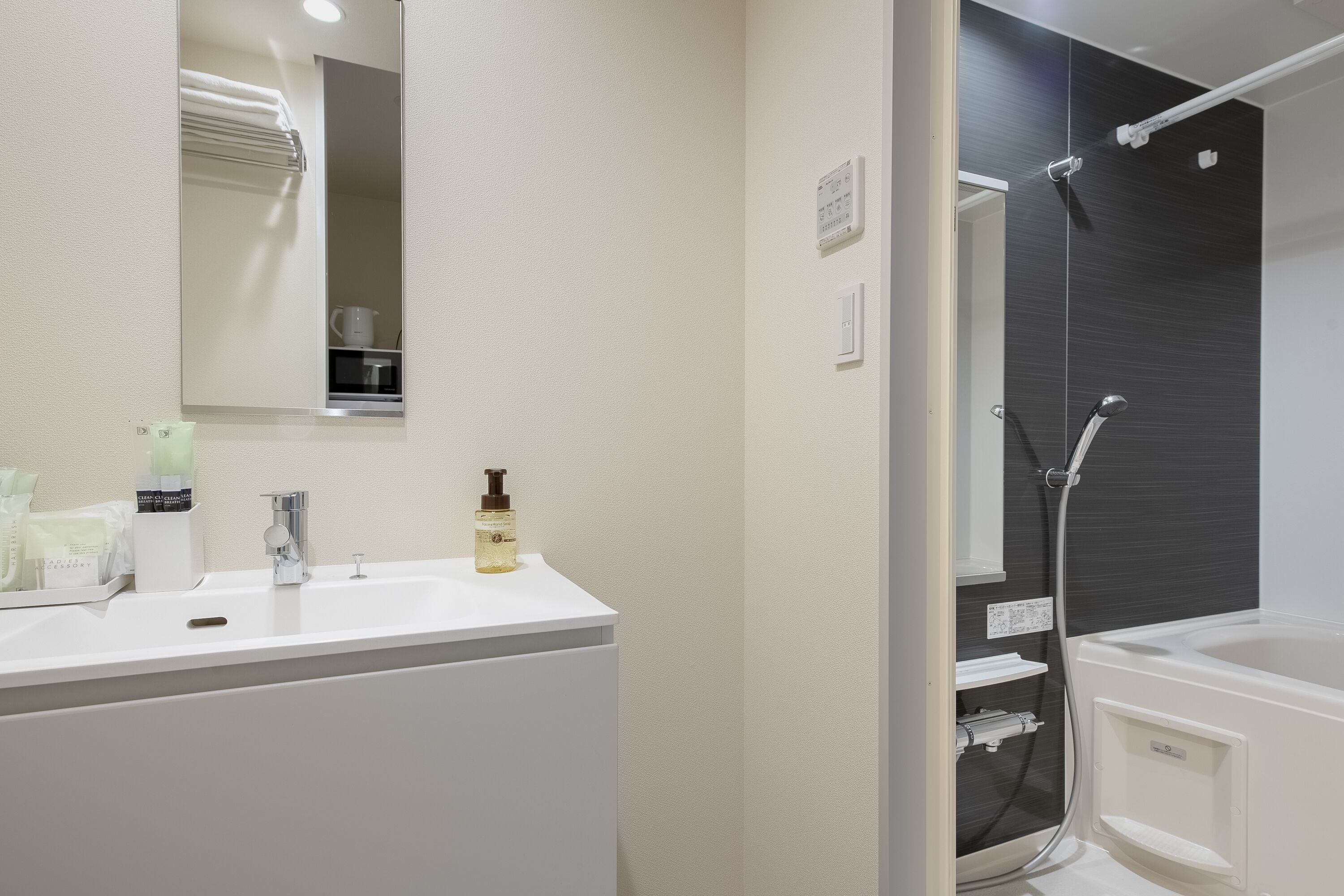 A modern bathroom with a white sink, a mirror, a shower, and a bathtub.