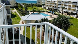 Um resort com edifícios de vários andares, piscina e vista para o mar.