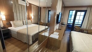Una habitación de hotel moderna con una cama grande, un escritorio, una silla y un televisor.