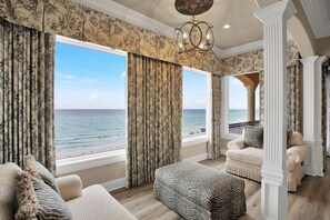 A room with large windows overlooking the ocean, a chandelier, and classic furniture. - Grand Marquix|Private Deeded Beach|Gulf Front Retreat w/ views|Private Pool (Destin)