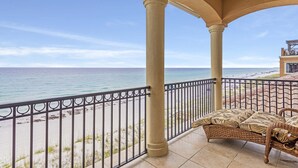Un balcon avec vue sur la plage et l’océan.