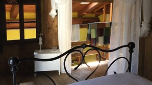 Une pièce en bois avec un lit, une table de chevet et une fenêtre avec des rideaux.