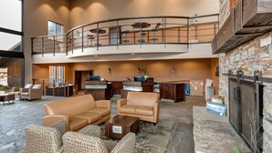 A spacious lobby with leather sofas, a fireplace, a reception desk, and a mezzanine with a balcony. - 3 Bedrooms, 3 Baths, Gas Fireplace | Sleeps 8 | Moose Mgt 536 (Park City)