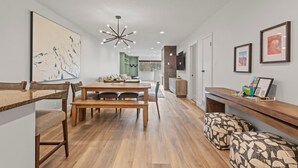 A modern interior with a wooden dining table, benches, a sofa, and a TV on the wall. - 3 Bedrooms, 3 Baths, Gas Fireplace | Sleeps 8 | Moose Mgt 536 (Park City)