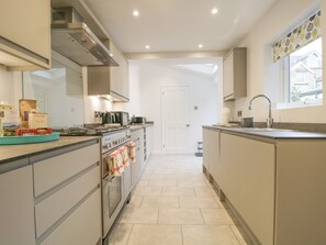 Une cuisine moderne dotée d’un îlot central, d’un four encastré et d’appareils électroménagers en acier inoxydable.