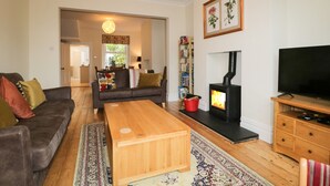 A living room with a sofa, a coffee table, a fireplace, a TV, and a bookshelf. - Shields (Keswick)