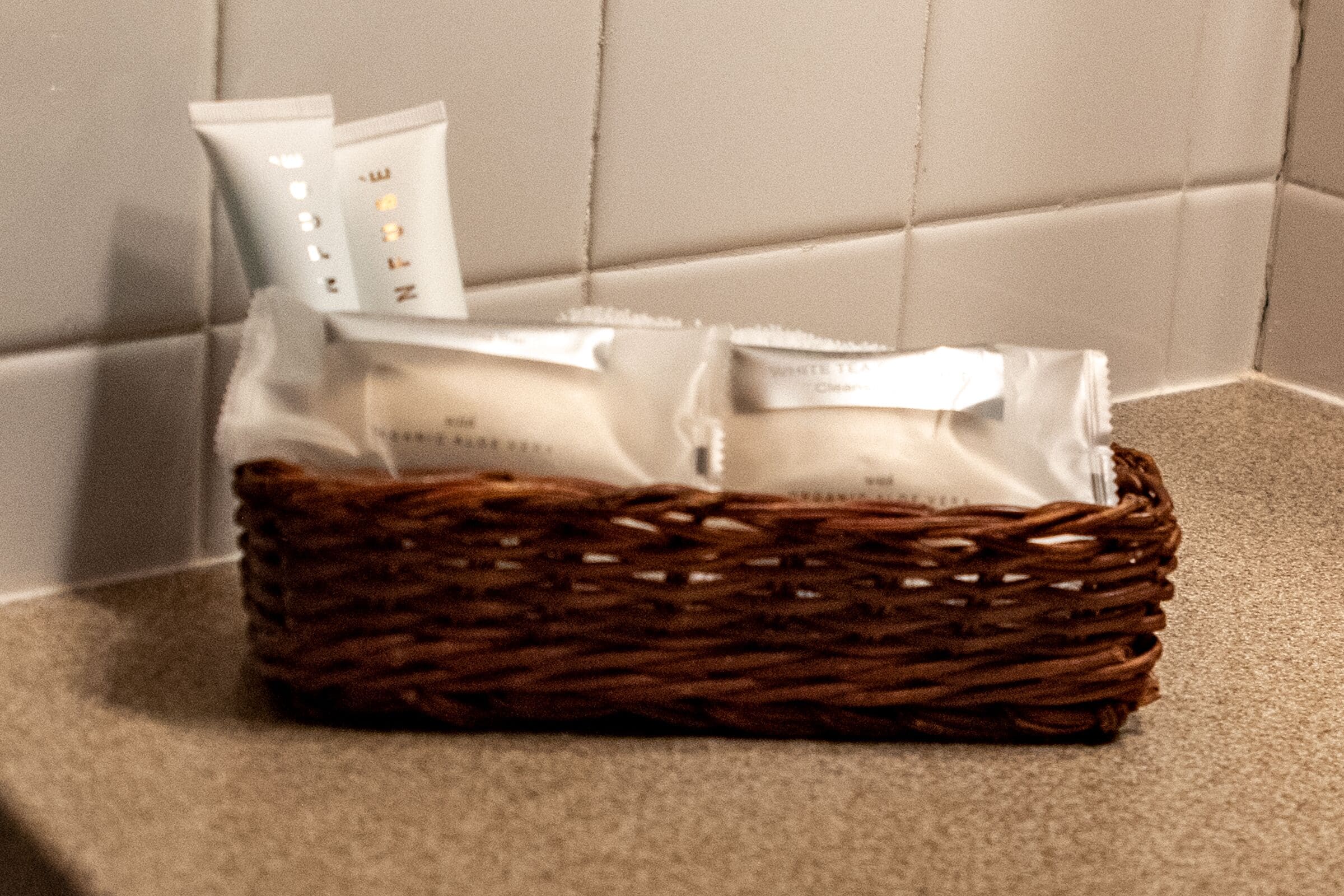 A wicker basket containing toiletries on a textured surface.