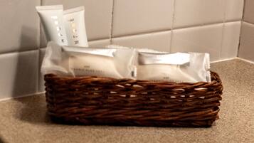 A wicker basket containing toiletries on a textured surface.