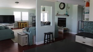 Een woonkamer met een televisie, bank en open haard.