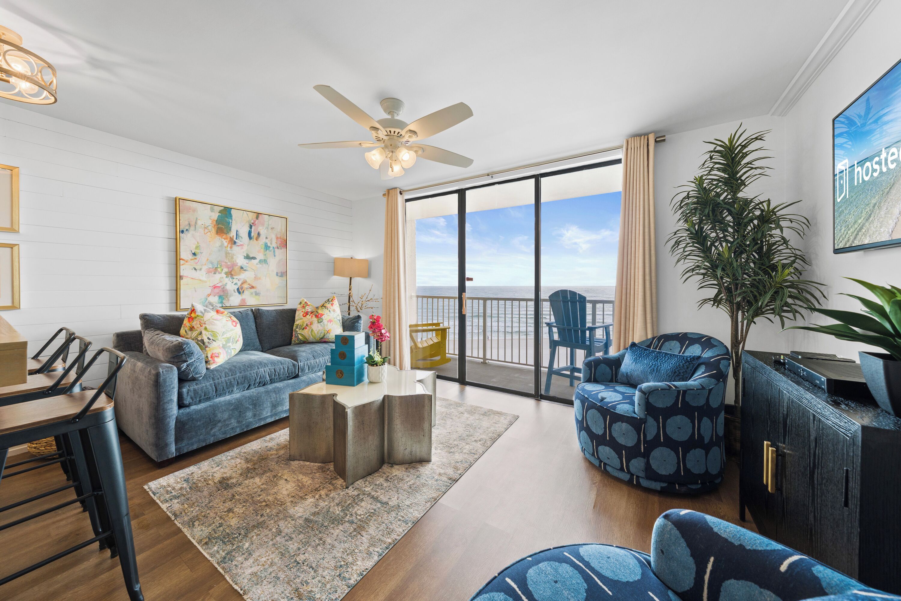 A spacious living room with a sofa, armchair, and a dining area.