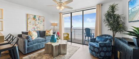 A spacious living room with a sofa, armchair, and a dining area.