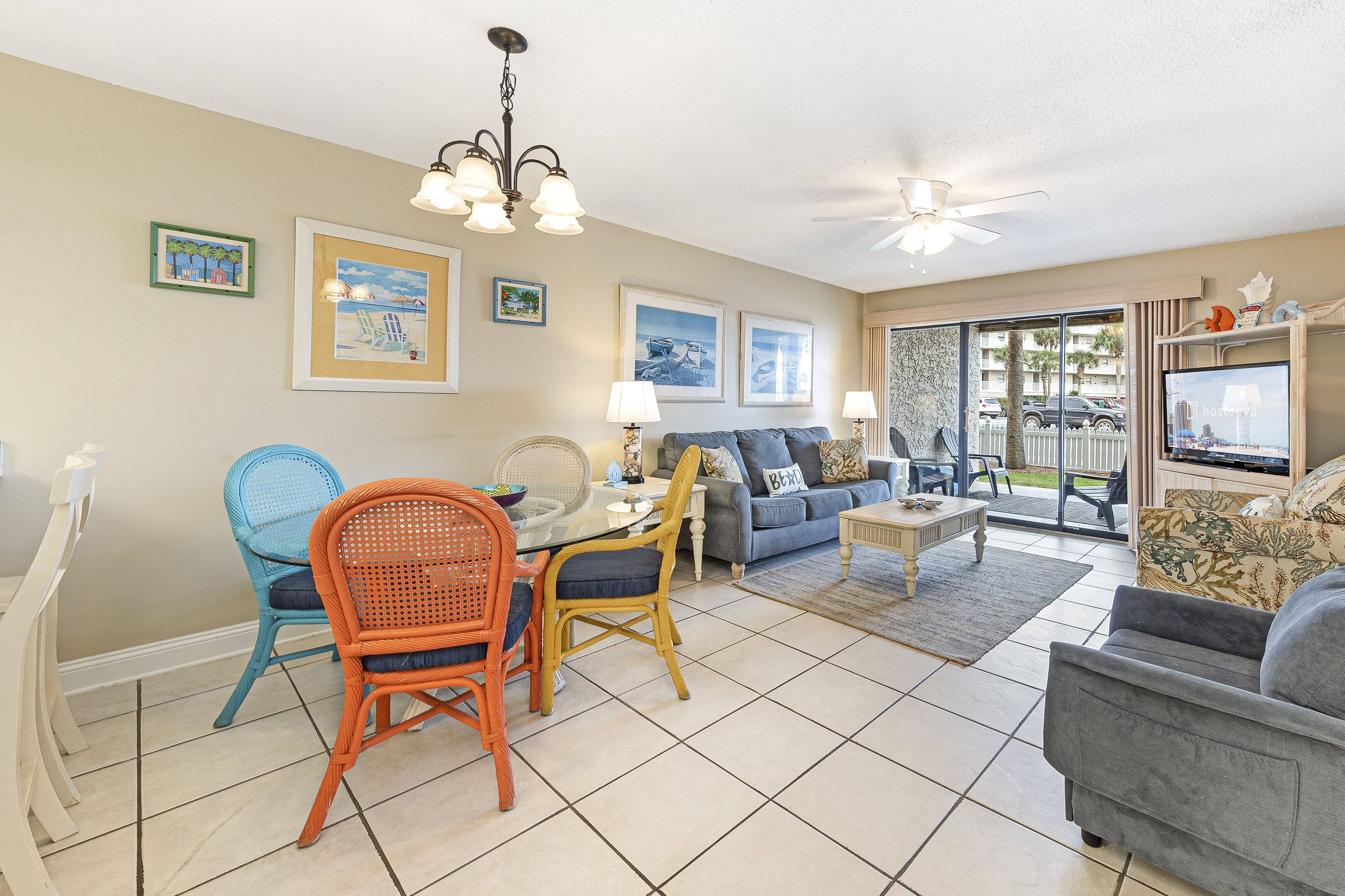 A spacious living area with a dining table, chairs, sofas, and a television.