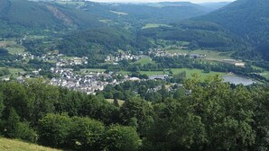A town nestled in a valley with a lake and forested hills in the background. - La Belle Auvergne 1 / F2 - 3 people (Condat)