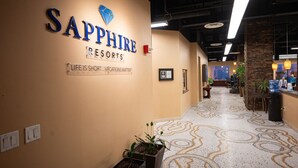 A corridor with a sign reading "Sapphire Resorts" and a motto "Life is short... vacations matter".