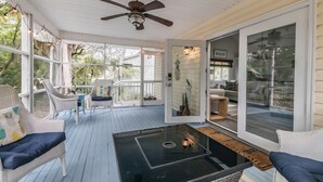 A covered porch with wicker furniture, a ceiling fan, and a glass door leading to an interior space. - Fripp Island/Multi Family Friendly/ Dog Friendly/Spacious 3rd Row home/6 Seater Golf cart incl/-703 Amberjack (Fripp Island)