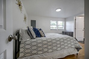 Un dormitorio con cama, un radiador y una ventana con persianas.