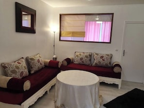 Relax in this inviting living room with a sofa, dining table, and floor lamp.