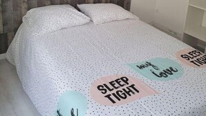 A bedroom with a wooden headboard, a bed with white bedding, and decorative pillows. - La Belle Auvergne 2 / Ground floor F3 - 5 people (Condat)