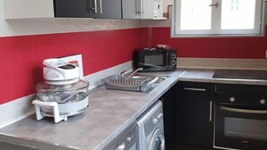 Eine kleine Küche mit Waschmaschine, Mikrowelle und Toaster.